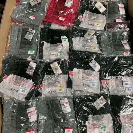 Pallet of assorted wholesale T-shirts in various colors and sizes, shrink-wrapped for bulk liquidation sale